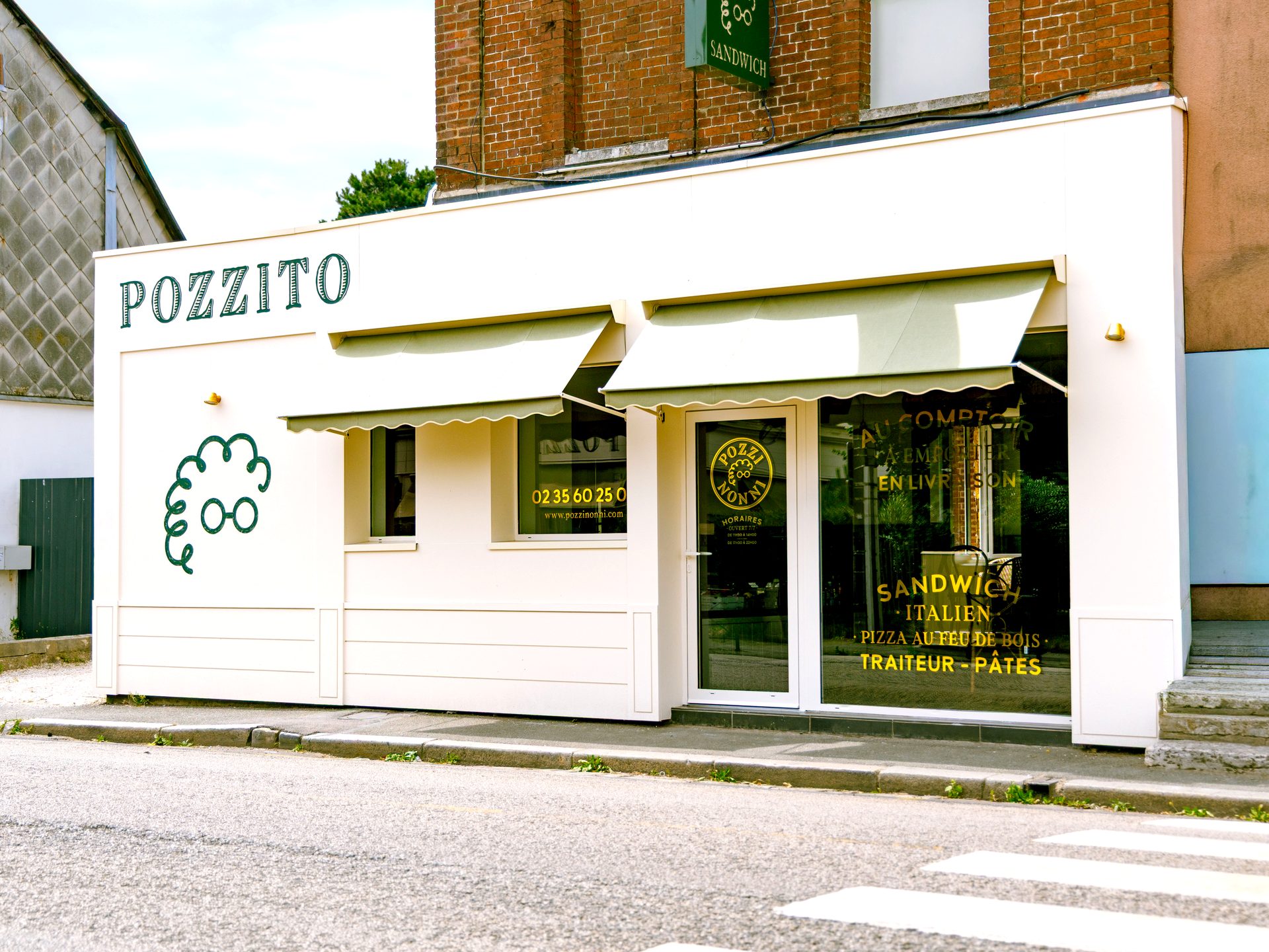 La devanture blanche du comptoir Pozzito à Bois-Guillaume, logo aux olives peint sur la façade